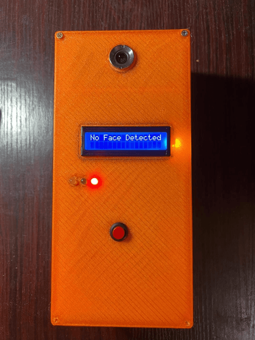 Front face of the printed enclosure, powered: camera at the top, a blue character LCD reading No Face Detected, three status LEDs with the red one lit, and a red push button